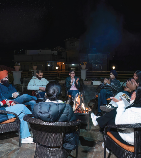Guests enjoying a cozy bonfire evening at Ojaswi Resort in Mukteshwar, sharing stories and warmth under the night sky