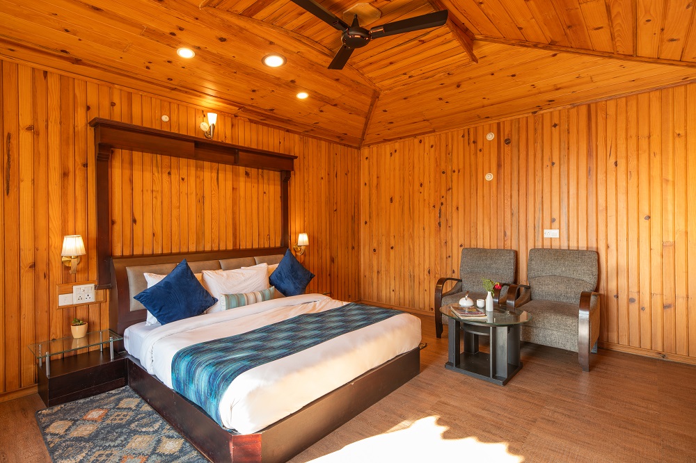 Deluxe Room at Ojaswi Resort Mukteshwar featuring warm wooden interiors and European-style luxury furnishings.