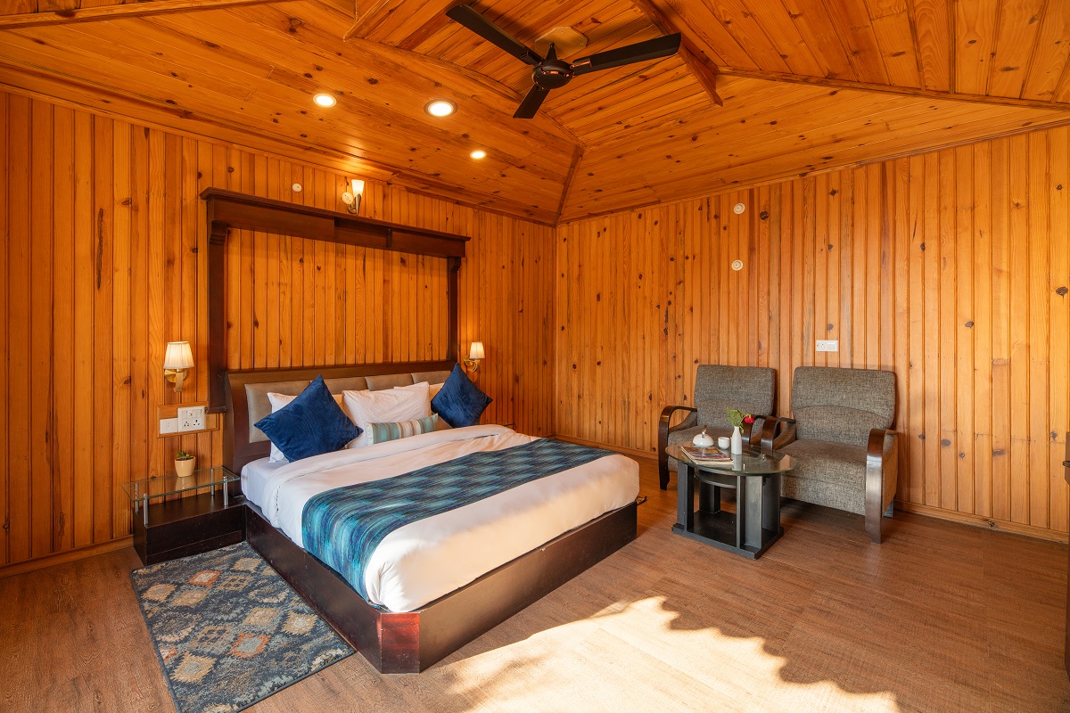 Deluxe Room at Ojaswi Resort Mukteshwar featuring warm wooden interiors and peaceful garden-facing views.