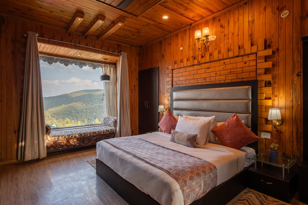 Jungle Retreat room at Ojaswi Resort Mukteshwar featuring British-inspired rustic design and mountain views.