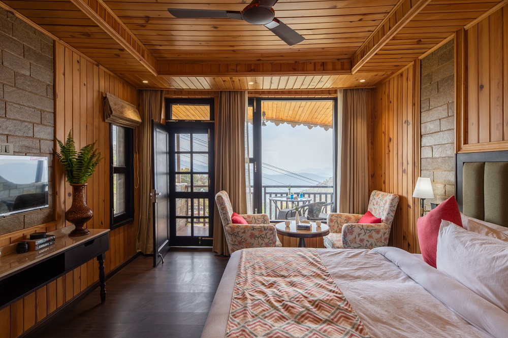 Sunset Retreat room at Ojaswi Resort Mukteshwar featuring private balcony with uninterrupted Himalayan valley views.