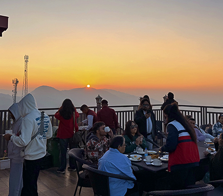 Guests enjoying a Sunset Hi-Tea on a deck with a stunning mountain view at Ojaswi Resort.